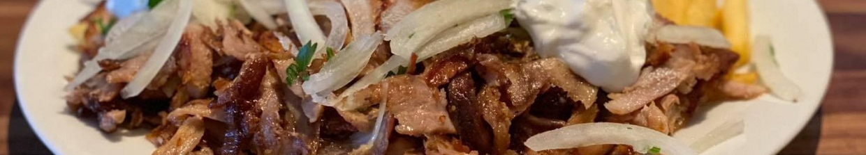 Gyros mit Zwiebeln und Zaziki auf einem Teller